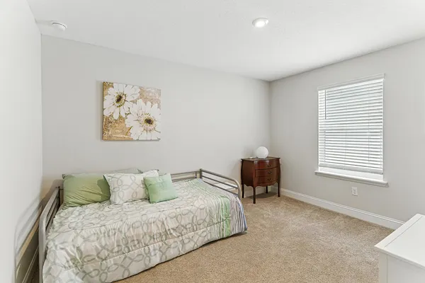 a spacious bedroom with a bed and a chair