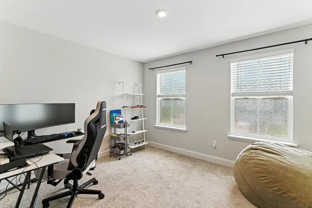 a view of a workspace with furniture and a window