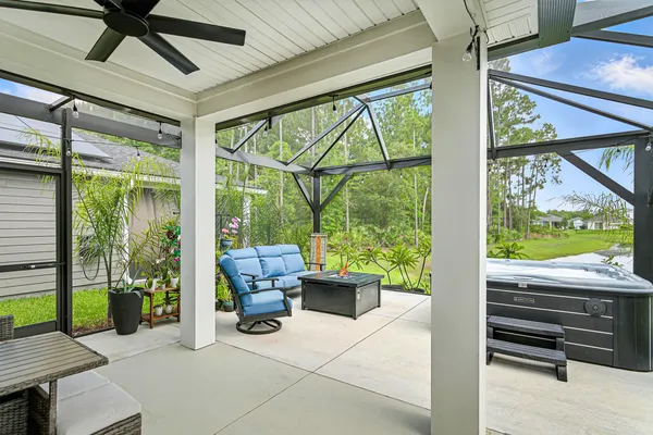 a living room with patio furniture and a floor to ceiling window