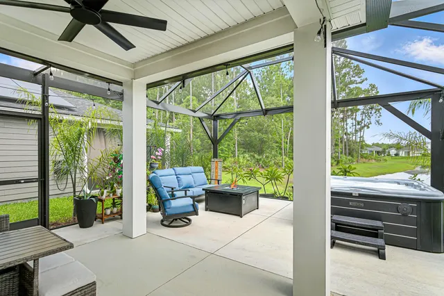 a living room with patio furniture and a floor to ceiling window
