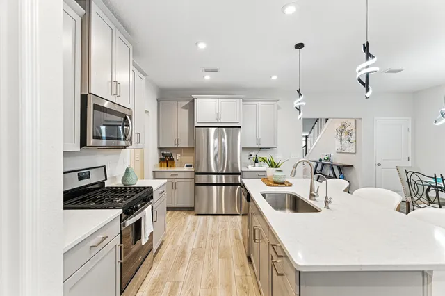 a kitchen with a sink a stove top oven a refrigerator cabinets and a center island