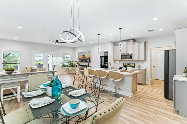 a view of a dining room and livingroom with furniture wooden floor kitchen view