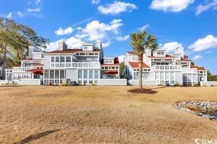 4396 Baldwin Avenue, Unit 82 Little River, SC 29566 - Photo 30 of 31 Back of property with a balcony, a chimney, and a yard