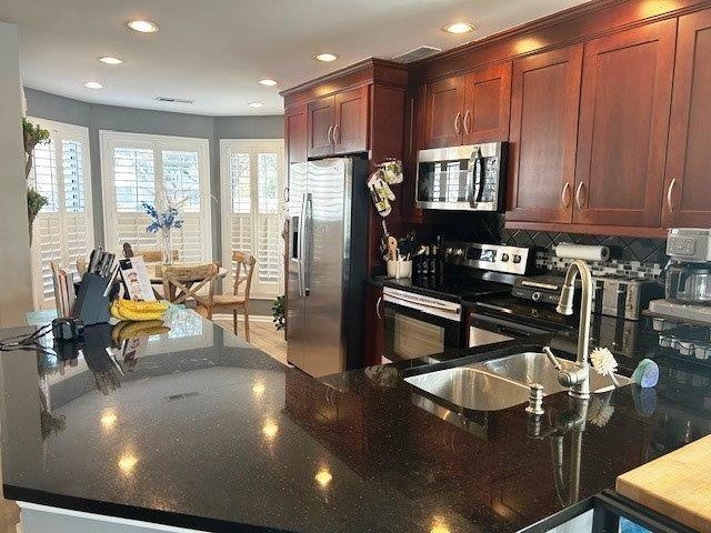 4396 Baldwin Avenue, Unit 82 Little River, SC 29566 - Photo 8 of 31 Kitchen with dark stone counters, appliances with stainless steel finishes, decorative backsplash, recessed lighting, and a peninsula