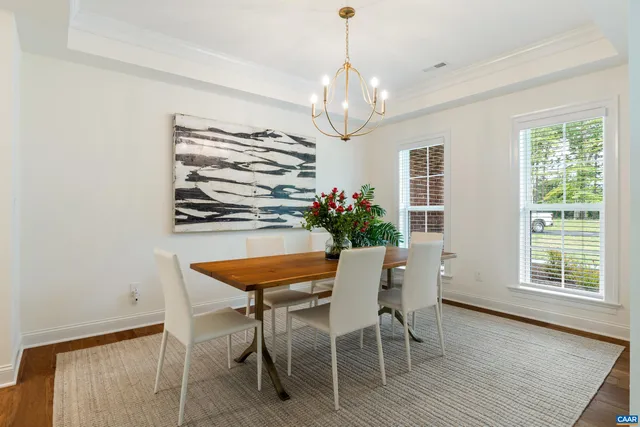 a kitchen with stainless steel appliances granite countertop a stove a sink dishwasher and a dining table with wooden floor