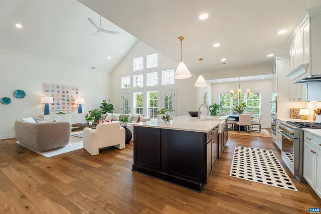 a kitchen with a sink a stove and chairs with wooden floor