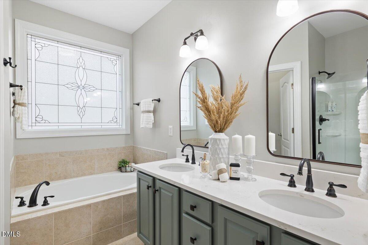 2000 Castana Court Willow Spring, NC 27592 - Photo 9 of 20 a bathroom with a tub a double sink and a mirror