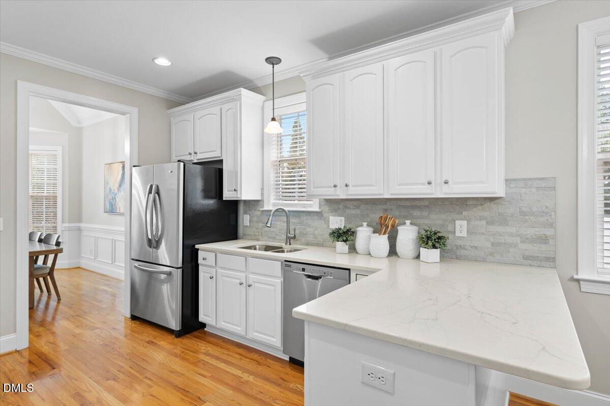 2000 Castana Court Willow Spring, NC 27592 - Photo 3 of 20 a kitchen with white cabinets and stainless steel appliances
