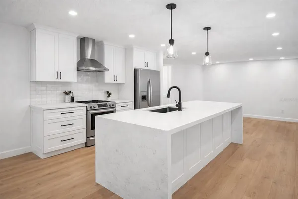 a kitchen with kitchen island a sink stainless steel appliances and cabinets