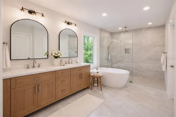 a spacious bathroom with a granite countertop sink a toilet a mirror and shower
