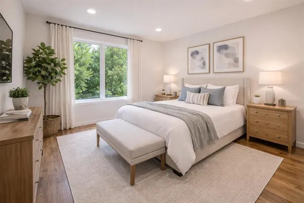 a bedroom with a large bed and a potted plant