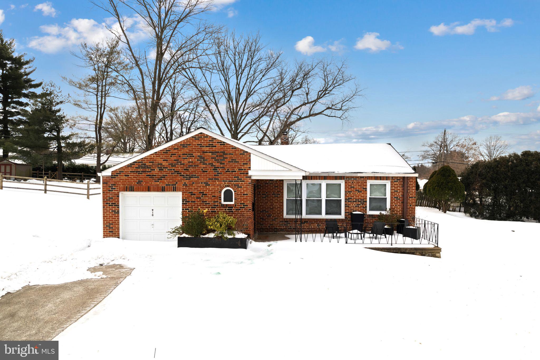 a front view of house with yard covered in snow