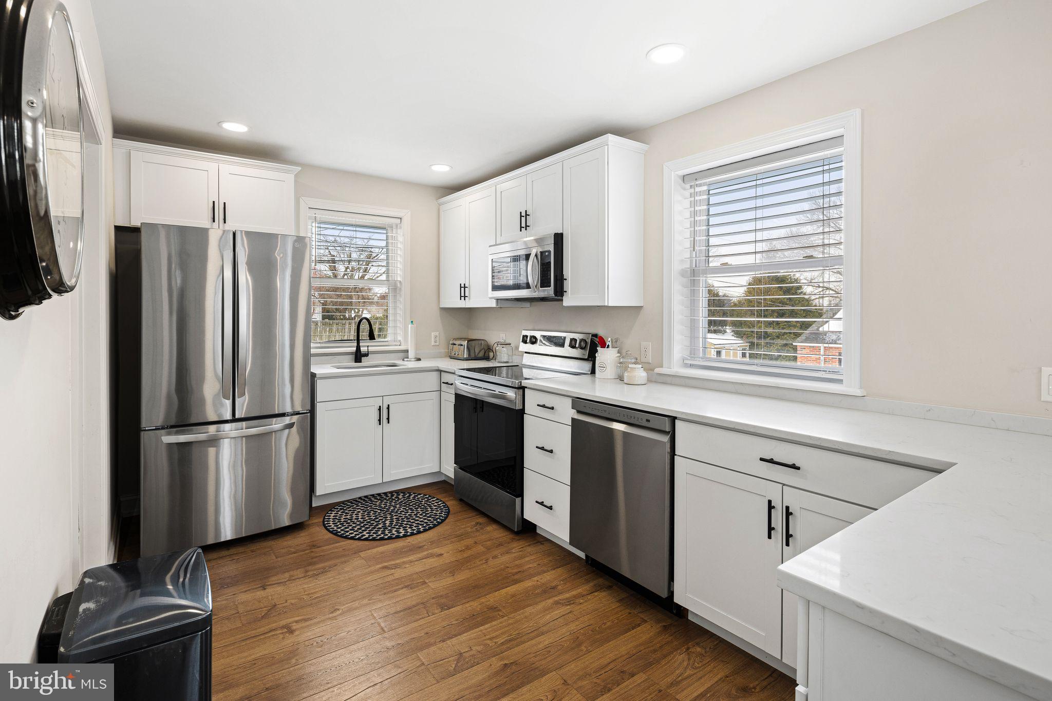 910 Edann Road Oreland, PA 19075 - Photo 11 of 26 a kitchen with a refrigerator wooden floor and window