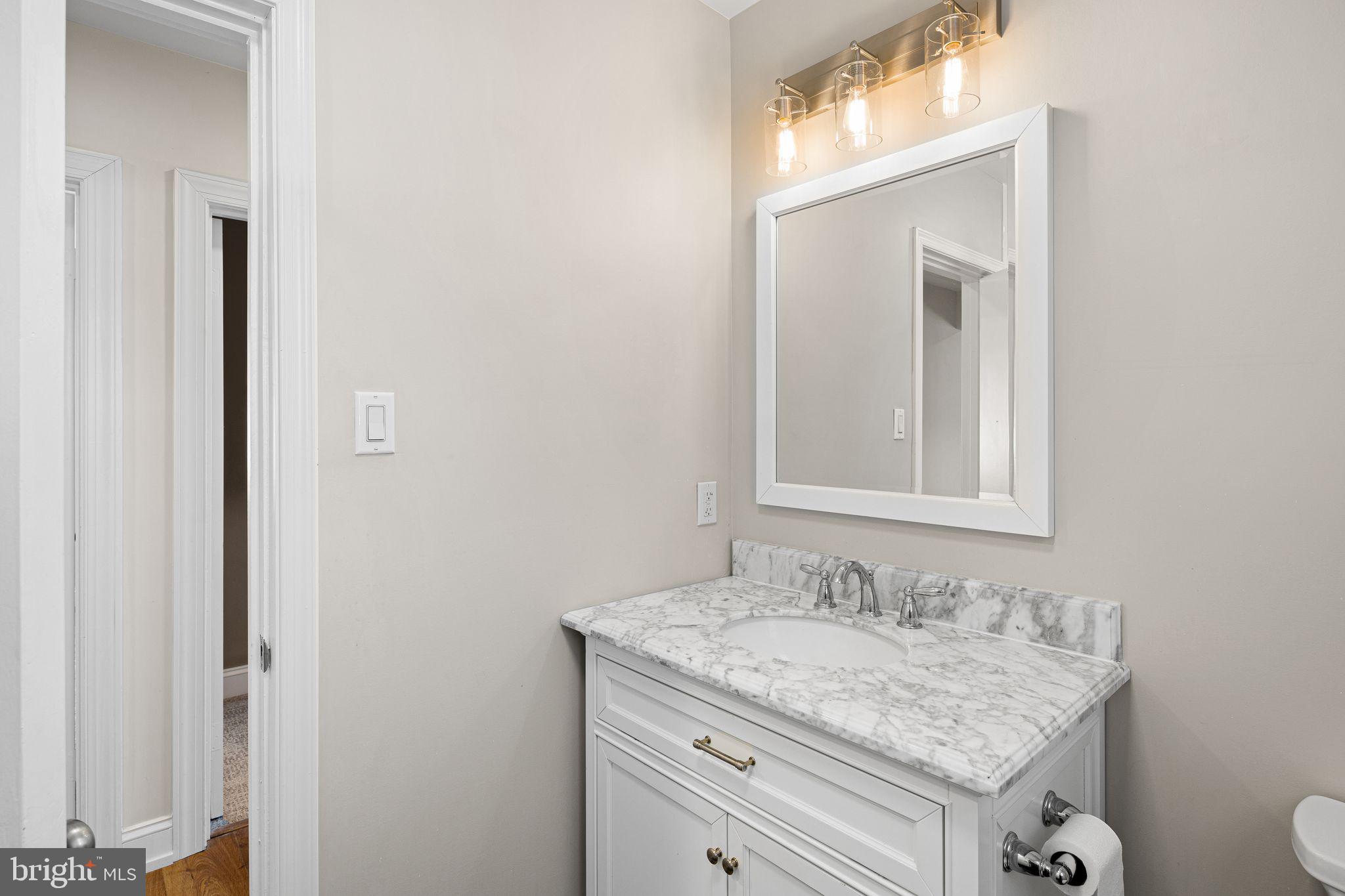 910 Edann Road Oreland, PA 19075 - Photo 20 of 26 a bathroom with a granite countertop sink and a mirror