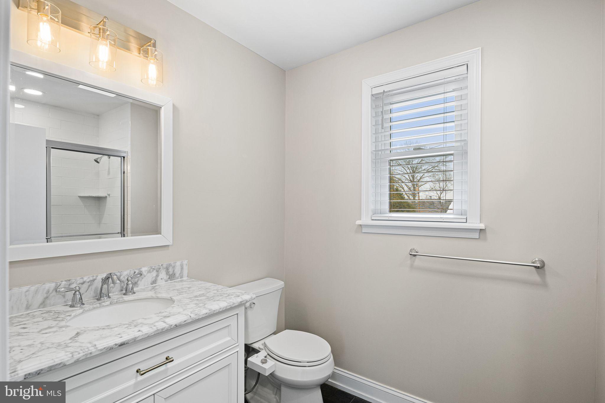 910 Edann Road Oreland, PA 19075 - Photo 22 of 26 a bathroom with a granite countertop sink a toilet and a mirror