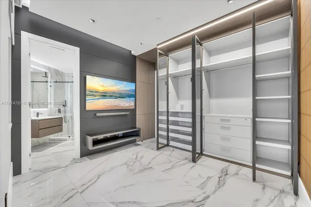 a view of an empty room with cabinet and mirrors