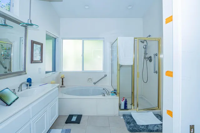 a bathroom with a tub sink and mirror