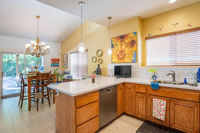 a living room with furniture flowerpot and a chandelier