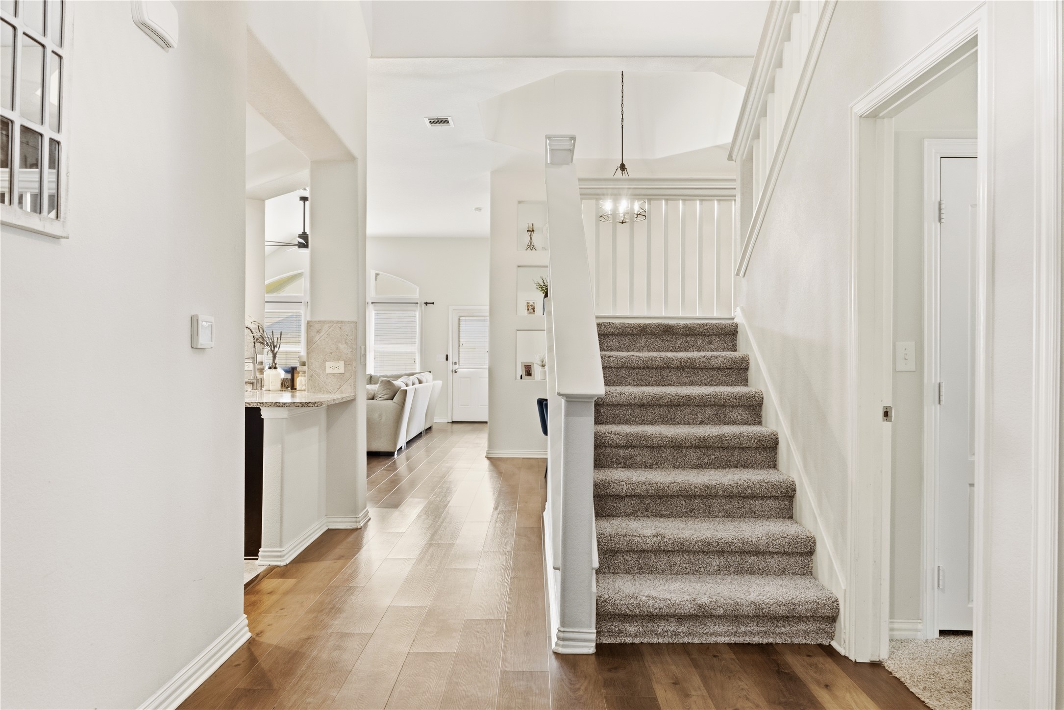 486 Pond View Pass Buda, TX 78610 - Photo 18 of 39 Interior entry hall featuring wood-finish flooring and a carpeted staircase with white balusters