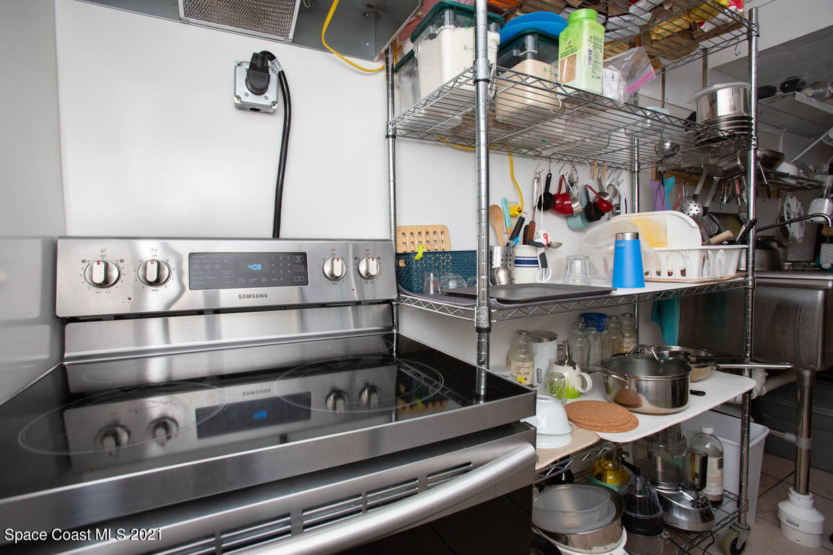 1609 North Wickham Road Melbourne, FL 32935 - Photo 12 of 12 a kitchen with lots of clutter and cabinets