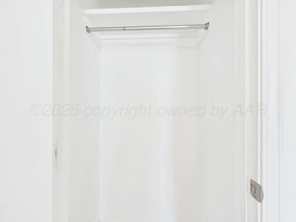 an empty room with a window and a ceiling fan