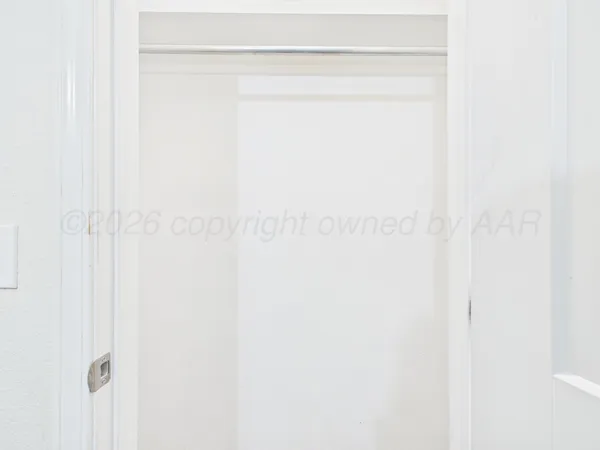 a view of a big room with wooden floor and chandelier fan