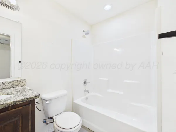 a bathroom with a granite countertop sink a toilet and bathtub