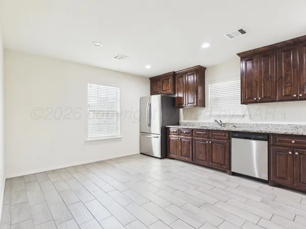 a kitchen with granite countertop wooden cabinets stainless steel appliances and a granite counter tops