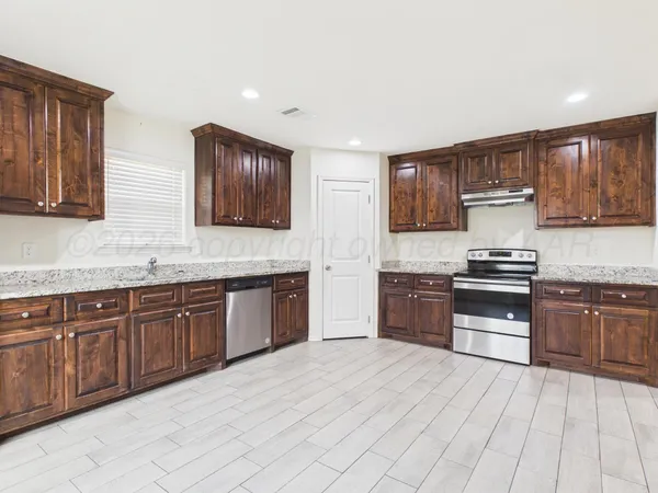 a kitchen with stainless steel appliances granite countertop a refrigerator and a sink