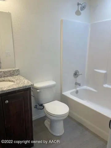 a bathroom with a granite countertop toilet a sink and bathtub