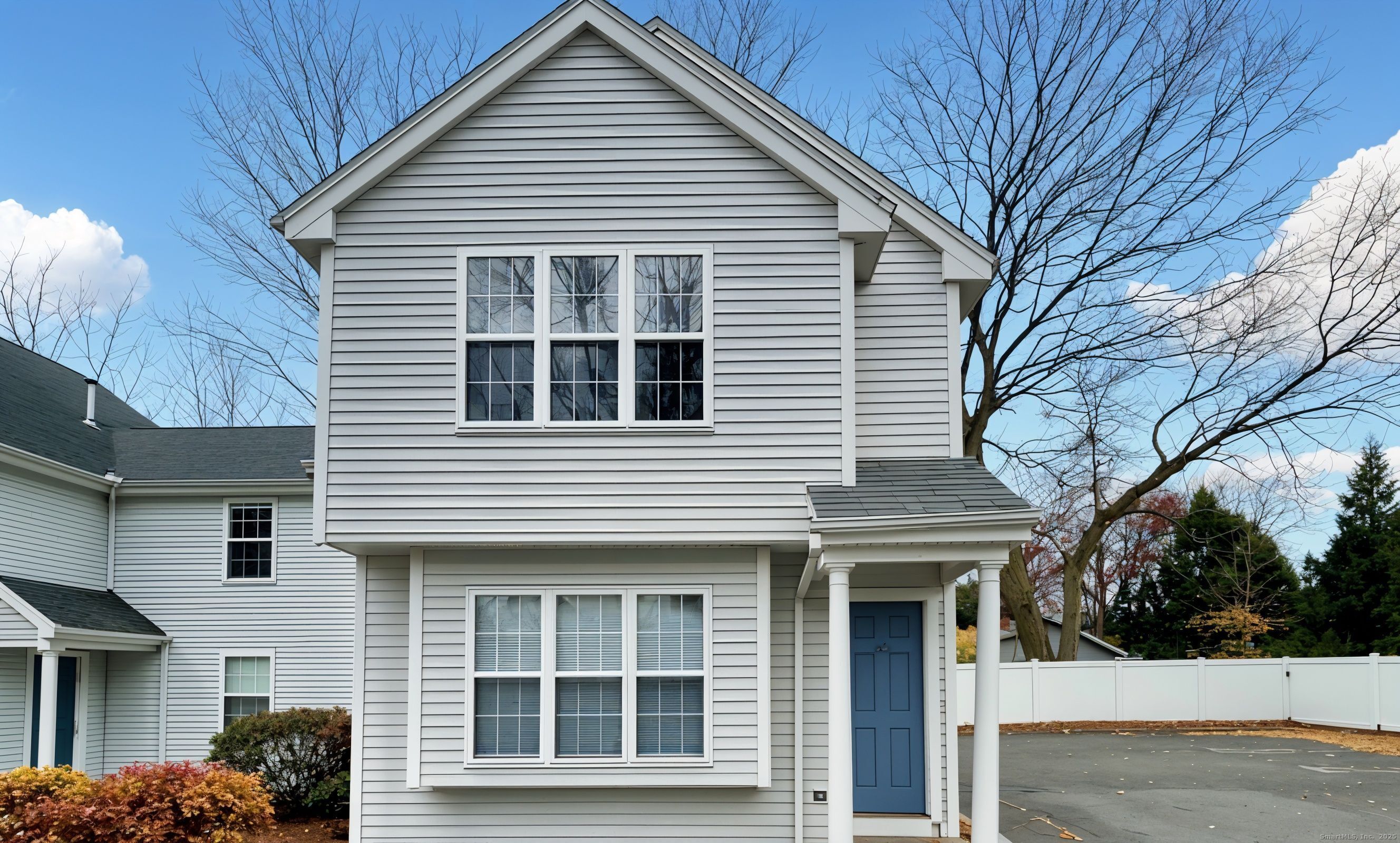 a front view of a house with a tree