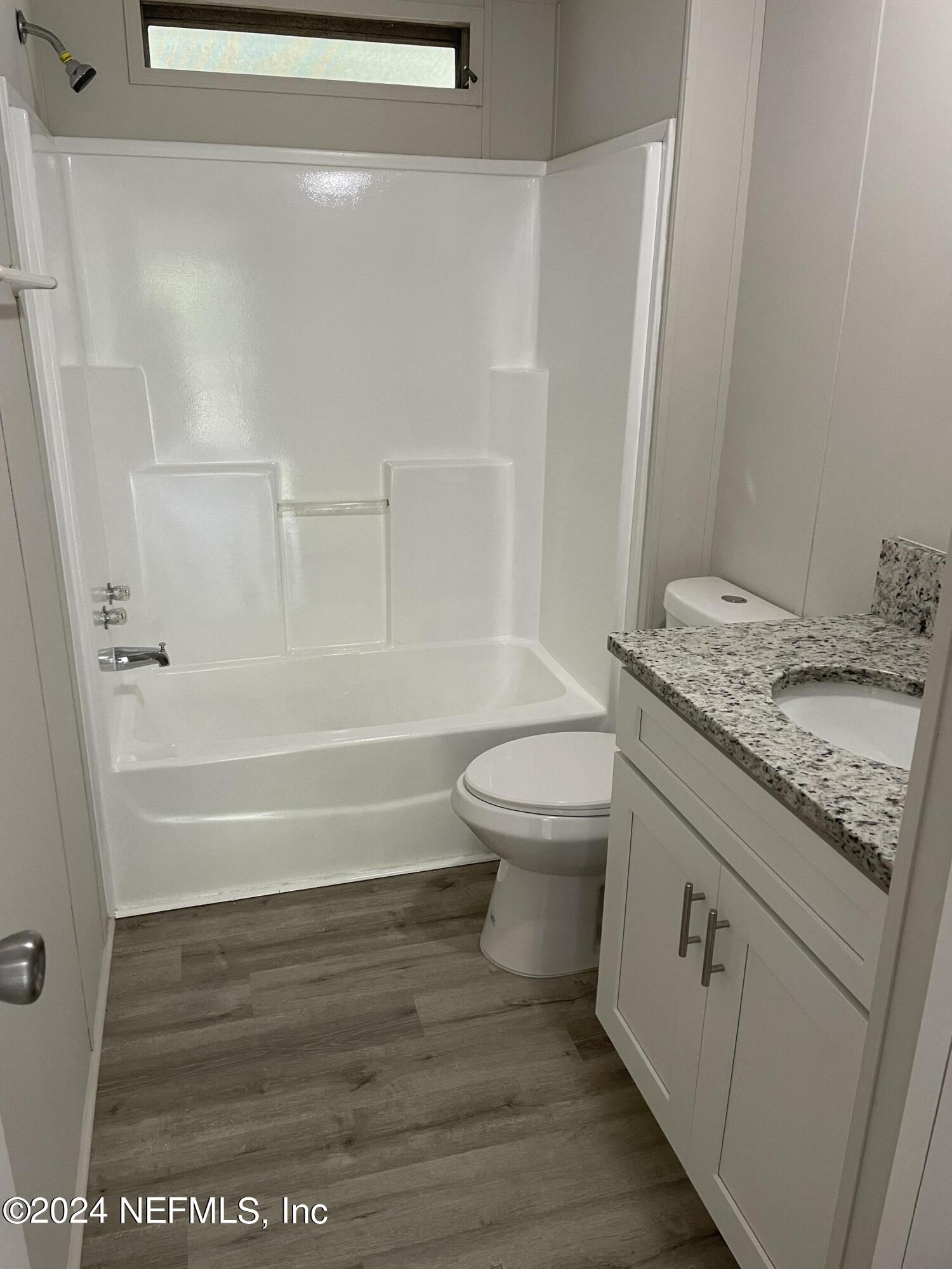 43621 Ratliff Road Callahan, FL 32011 - Photo 13 of 16 a bathroom with a granite countertop sink toilet and shower