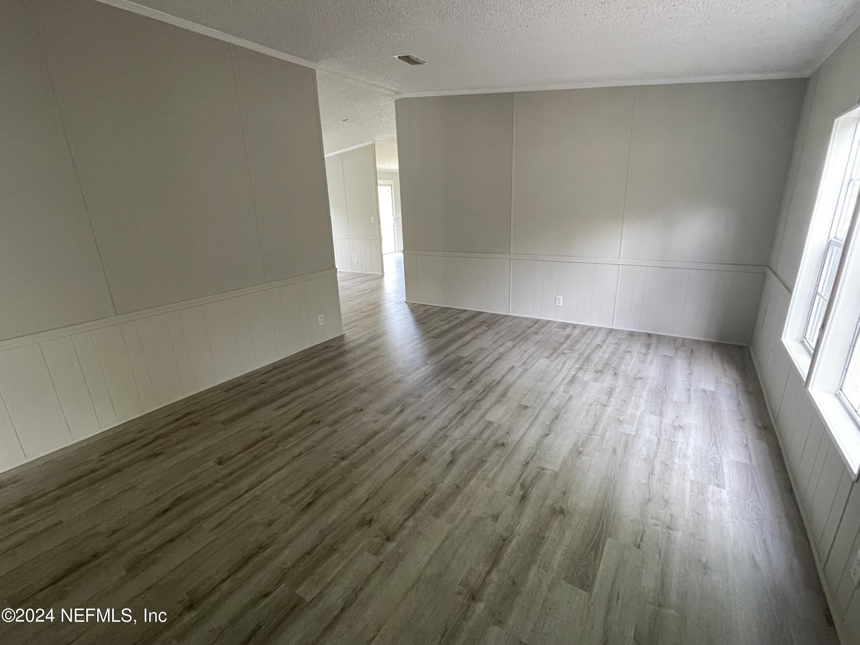 43621 Ratliff Road Callahan, FL 32011 - Photo 5 of 16 an empty room with wooden floor and windows