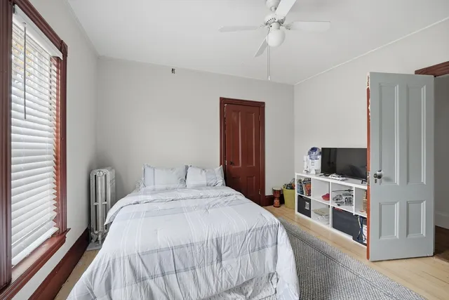 a bedroom with a bed and a flat tv screen on dresser
