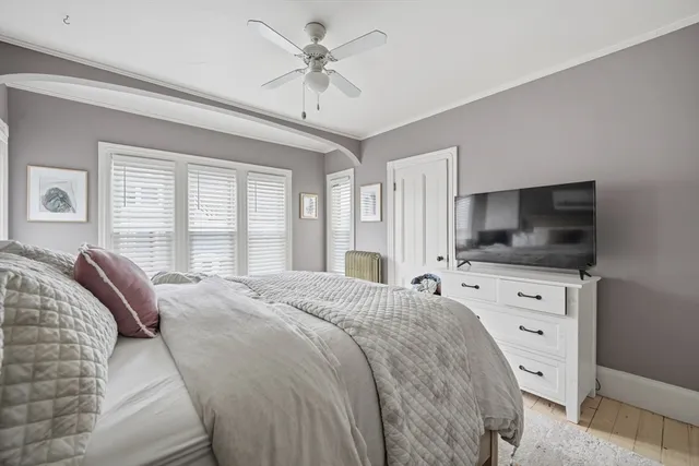 a bedroom with a large bed and a flat tv screen on dresser