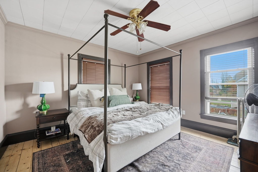 151 Lincoln Street Holyoke, MA 01040 - Photo 30 of 36 a bedroom with a bed next to a window with a potted plant on a dresser