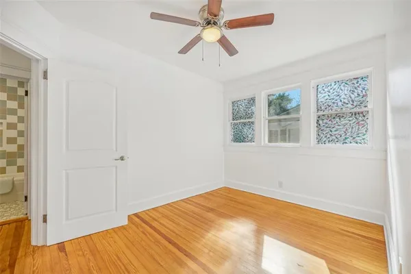 a view of a room with wooden floor and a ceiling fan