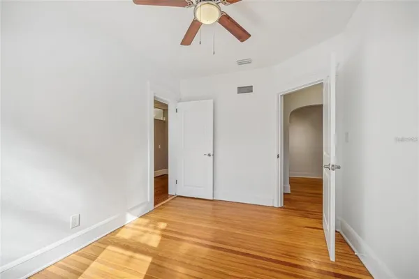 a view of empty room with wooden floor