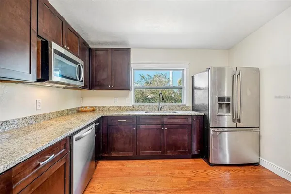 a kitchen with stainless steel appliances granite countertop a refrigerator stove and microwave