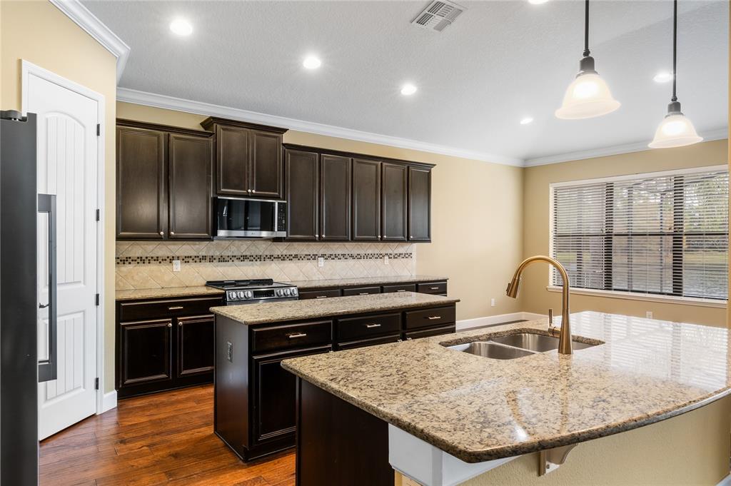 7167 Beek Street Windermere, FL 34786 - Photo 15 of 63 a kitchen with stainless steel appliances granite countertop a sink stove and refrigerator