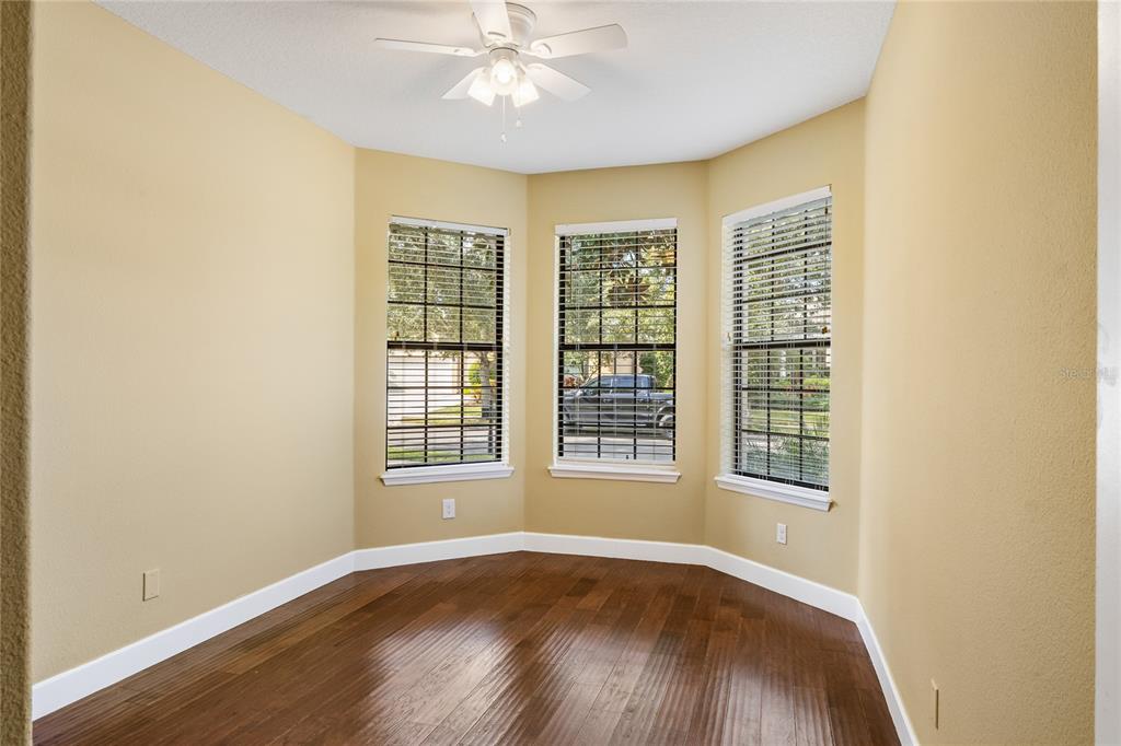 7167 Beek Street Windermere, FL 34786 - Photo 48 of 63 an empty room with wooden floor fan and windows