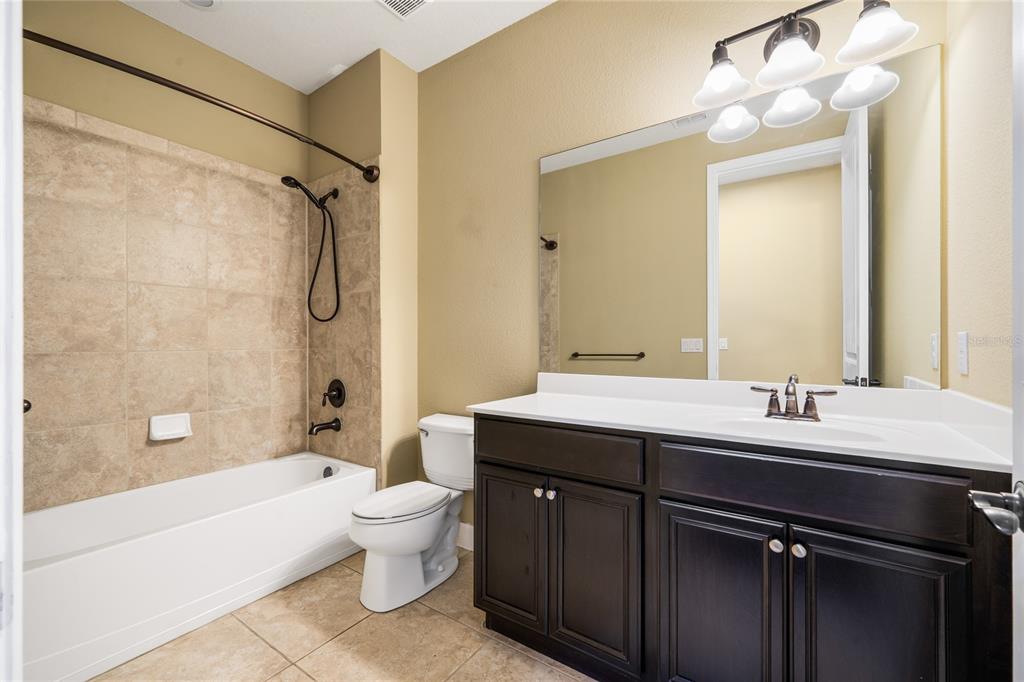 7167 Beek Street Windermere, FL 34786 - Photo 49 of 63 a bathroom with a double vanity sink toilet mirror and bathtub