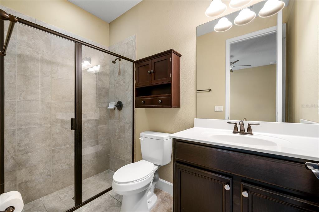 7167 Beek Street Windermere, FL 34786 - Photo 52 of 63 a bathroom with a sink a toilet a mirror and shower