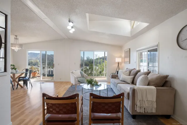 a living room with furniture a wooden floor and a large window