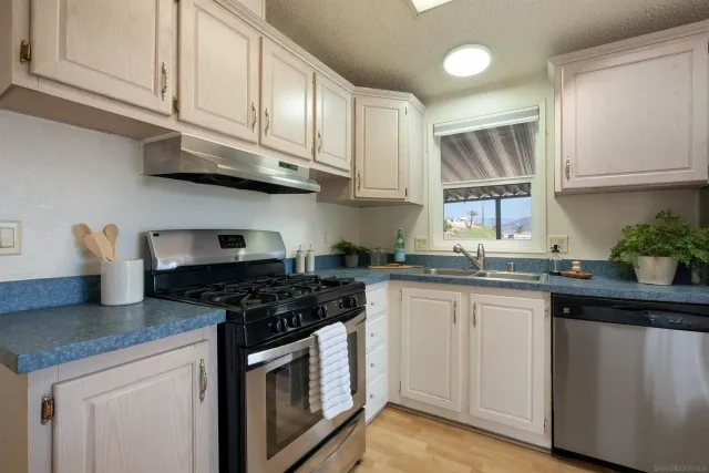 a kitchen with stainless steel appliances granite countertop a sink stove and cabinets