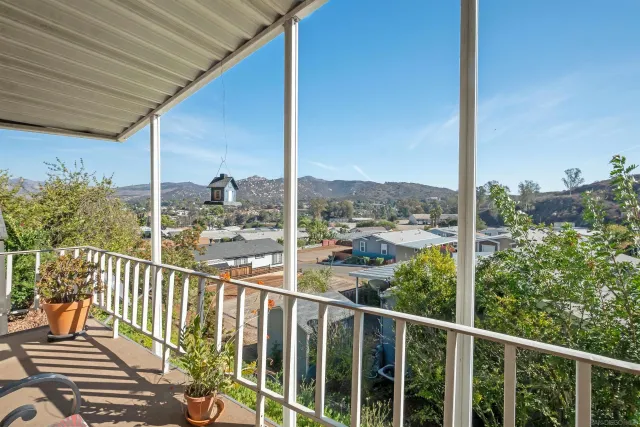 a view of a balcony with floor to ceiling window wooden fence and deck
