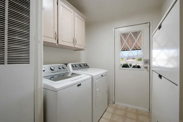 a utility room with cabinets washer and dryer