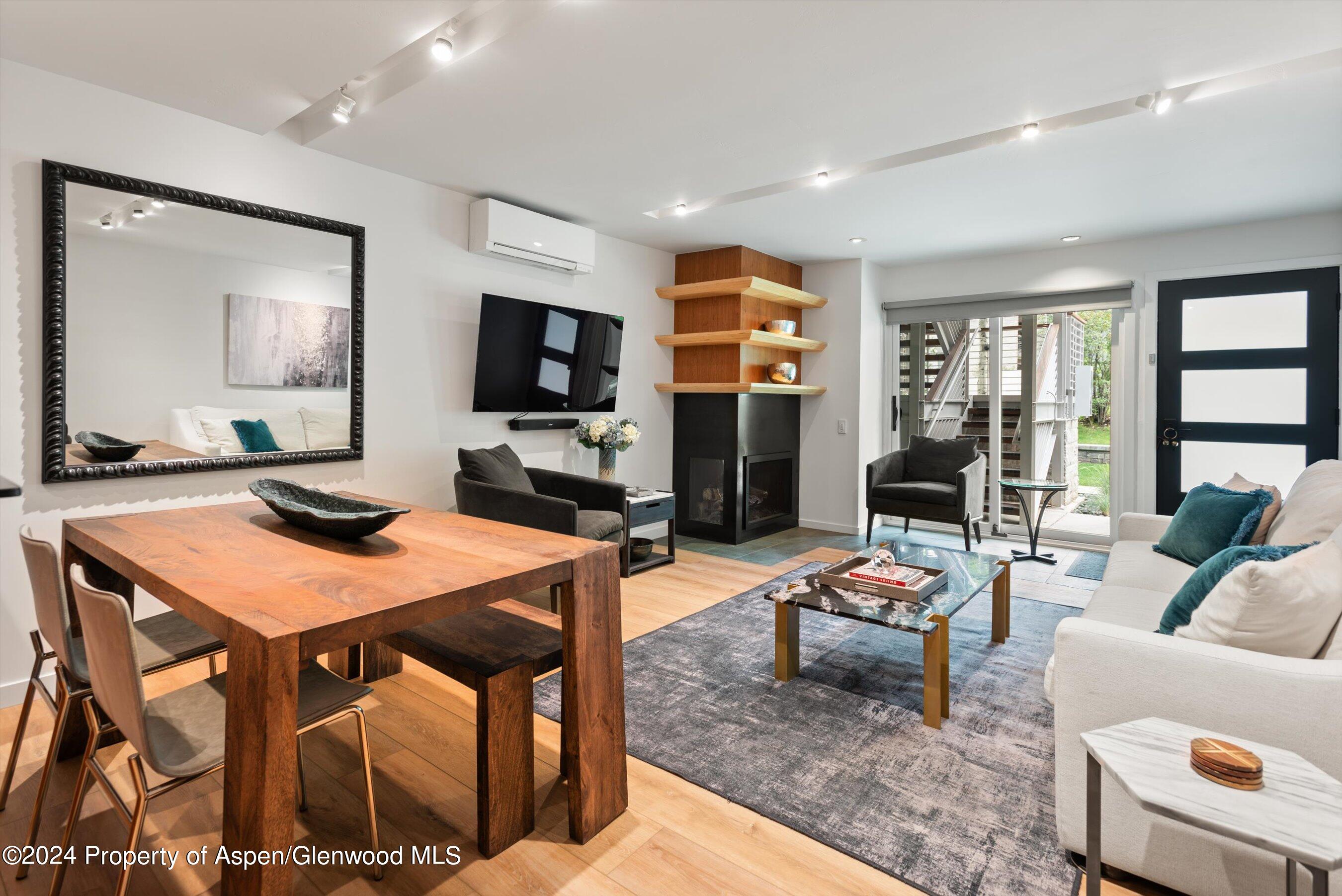 100 East Dean Street, Unit 1E Aspen, CO 81611 - Photo 3 of 10 a living room with furniture a flat screen tv and a table