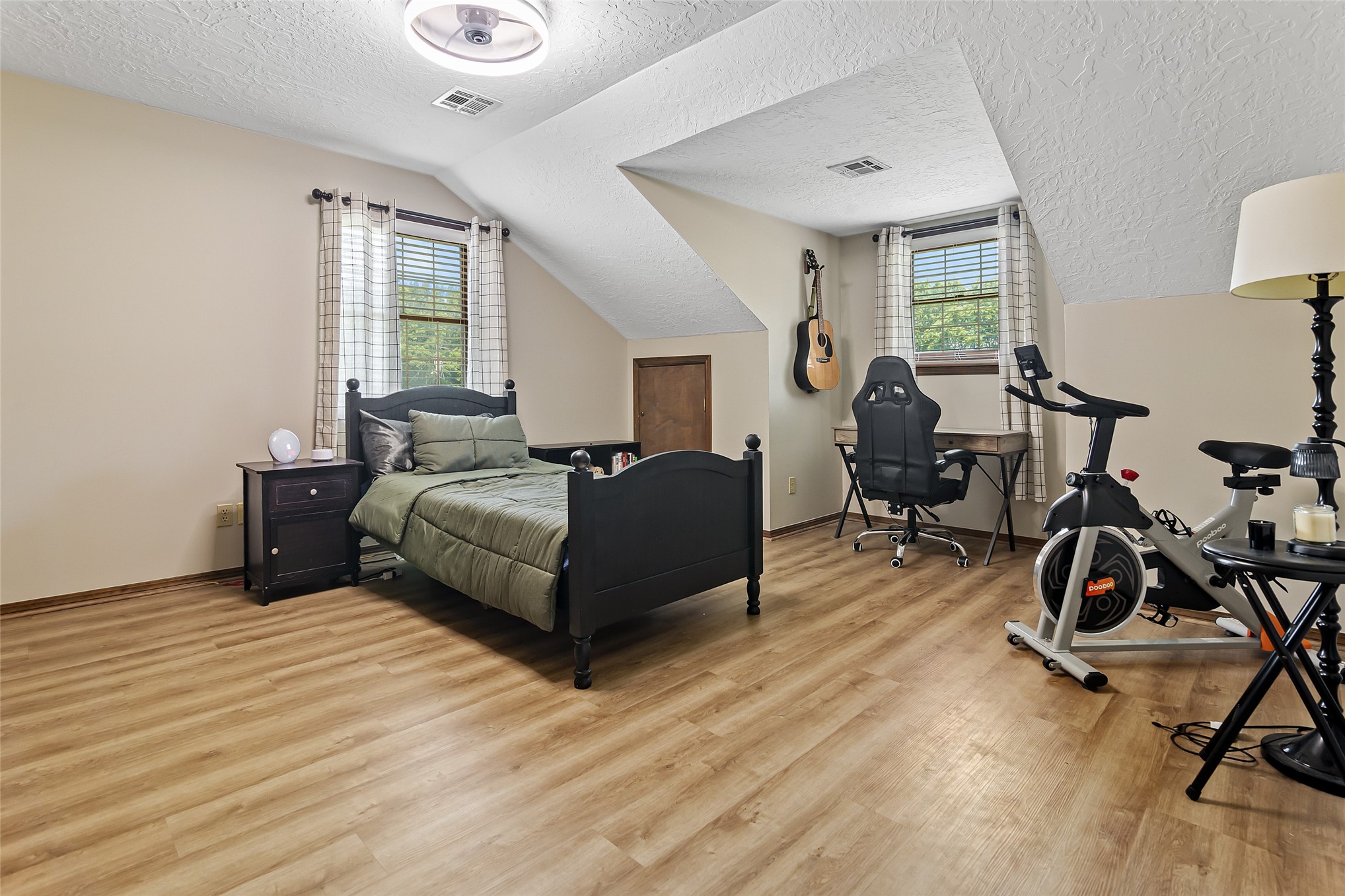 9644 19th Road Nowata, OK 74048 - Photo 19 of 36 Spacious room featuring wood-finish flooring, neutral-toned walls, and sloped ceiling details