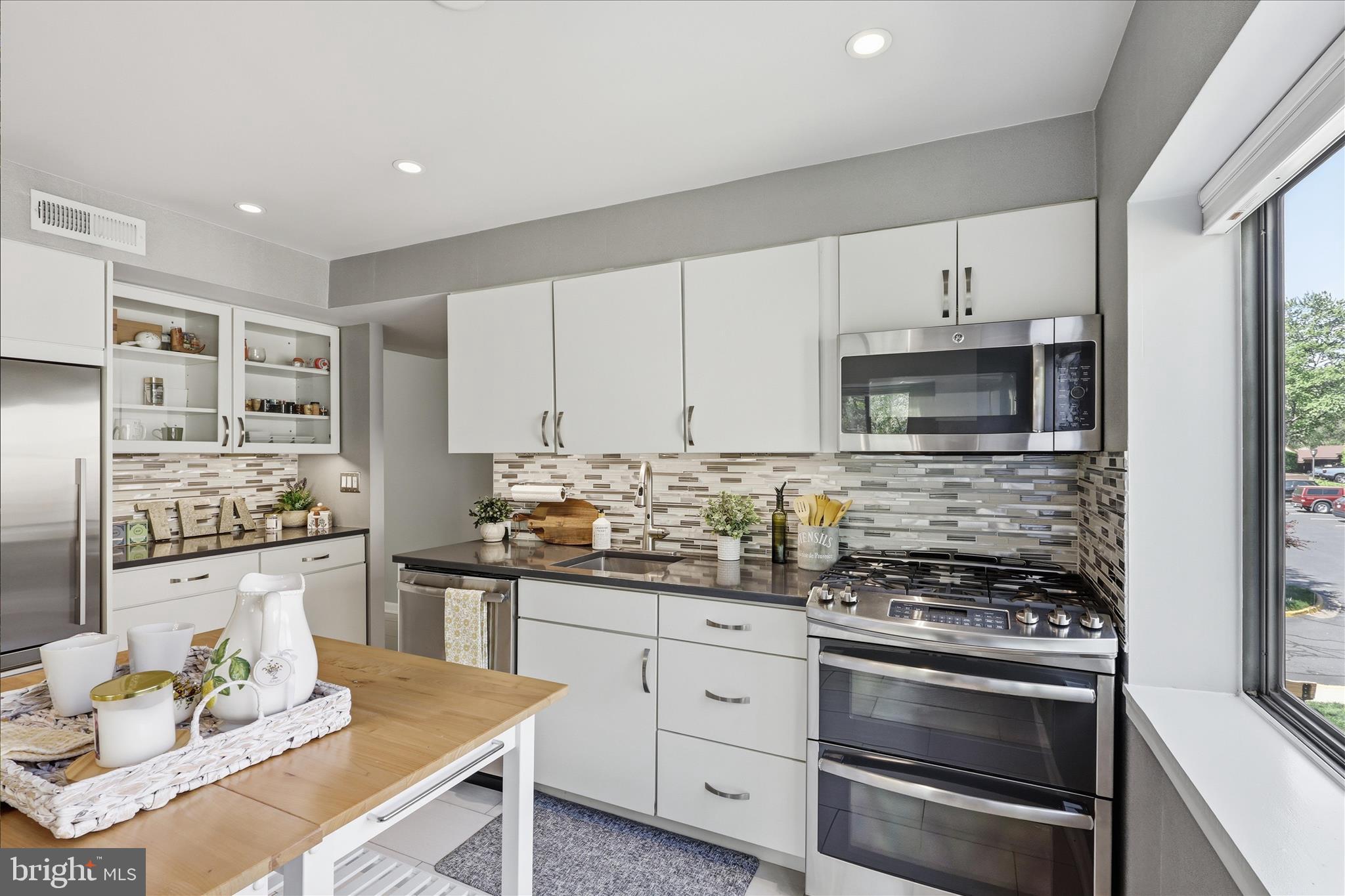 1661 Parkcrest Circle, Unit 5A/300 Reston, VA 20190 - Photo 8 of 22 a kitchen with stainless steel appliances a stove a sink a stove and white cabinets